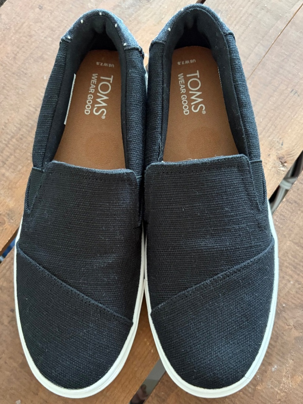 Tom’s black, slip on sneakers with polka dot logo heels.